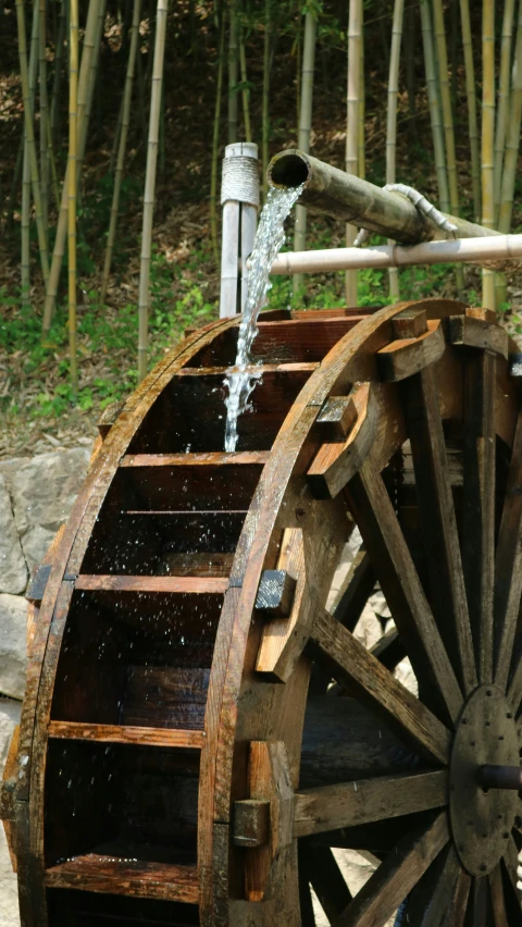 a water wheel is full of water with a stream