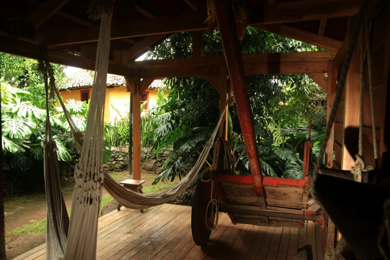 a porch with wooden roof and hammock swing