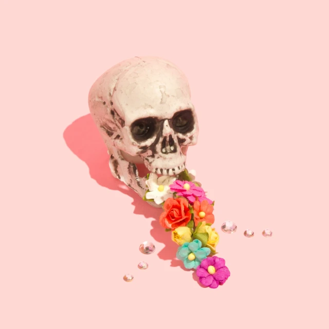 a skeleton with a bunch of flowers on a pink background
