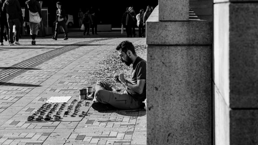 a person sitting on the ground reading soing