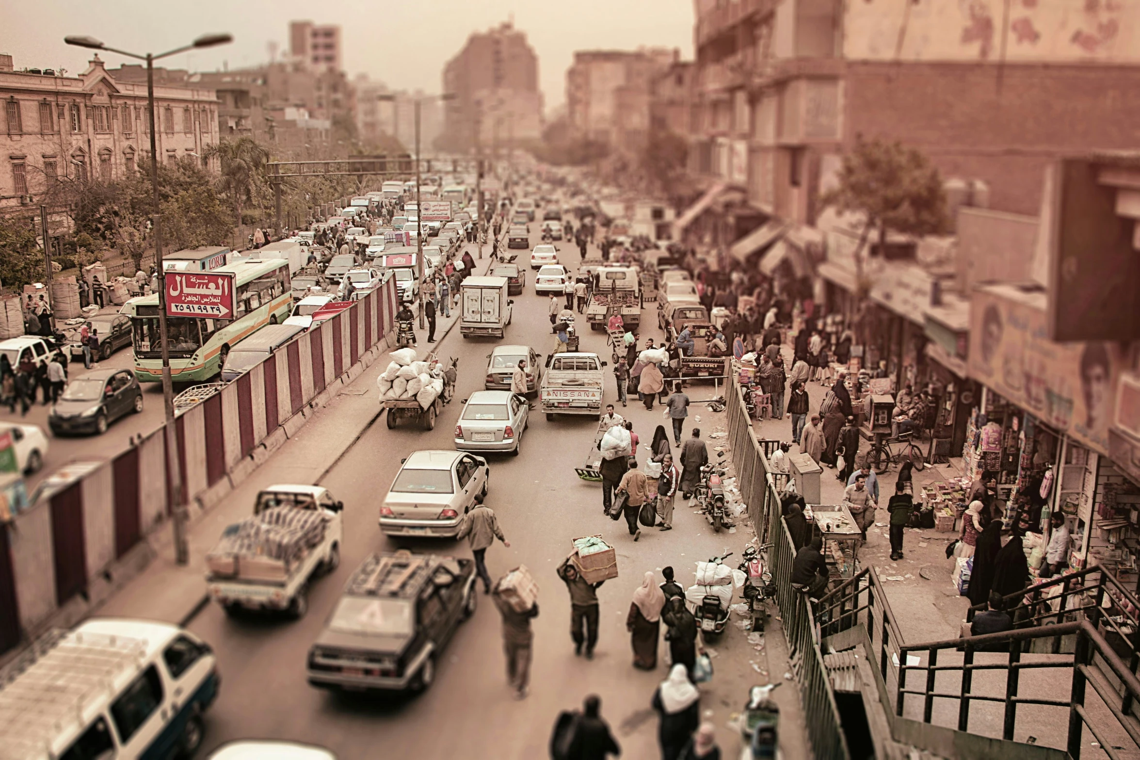 an old city street filled with people and cars