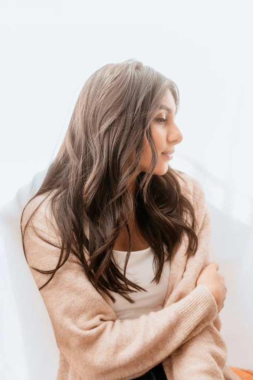 a woman is sitting on a bed with her arms crossed and looking to the side