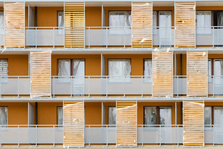 multiple balconies of apartment building against orange background