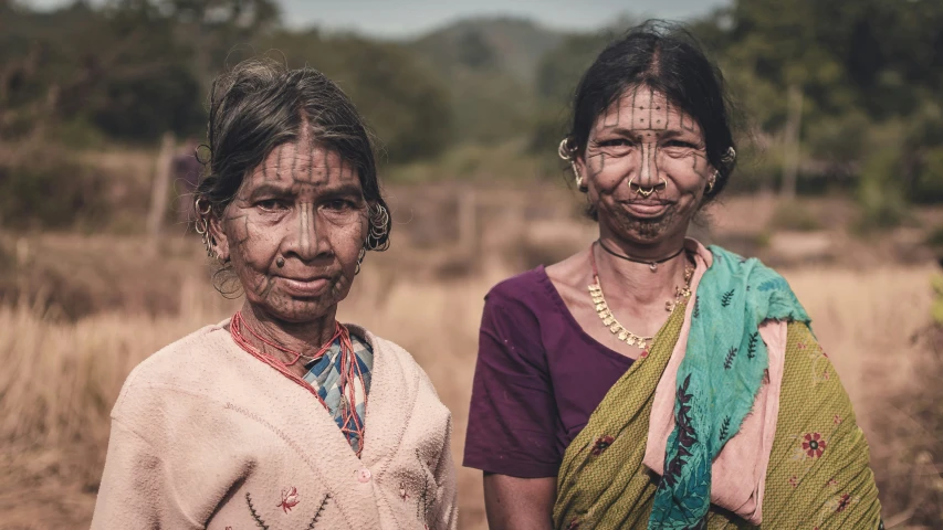 two indian women that have very mud smeared on their faces