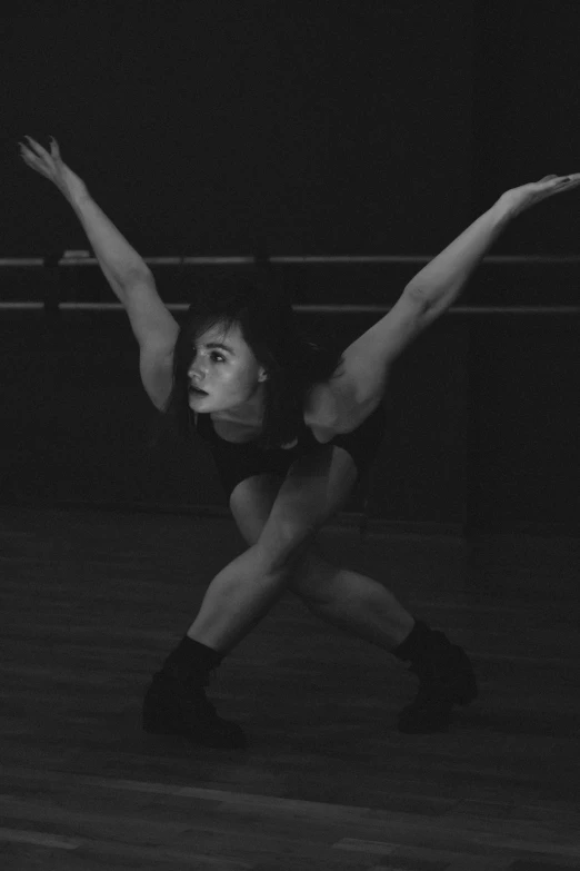 a woman is posing in the dark with her arms stretched up