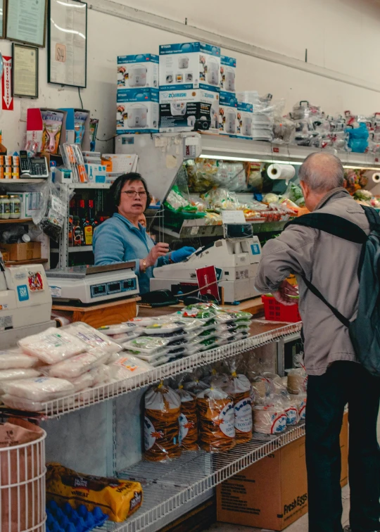 a man and woman standing in front of a market