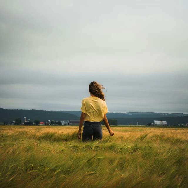 a person standing in a grass field watching the sky