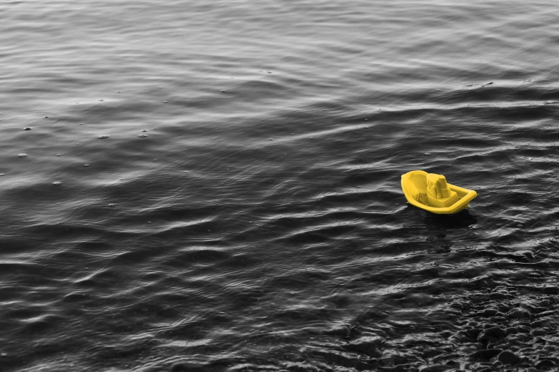 yellow object floating on large body of water