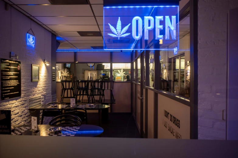 the inside of a bar with blue lights and chairs