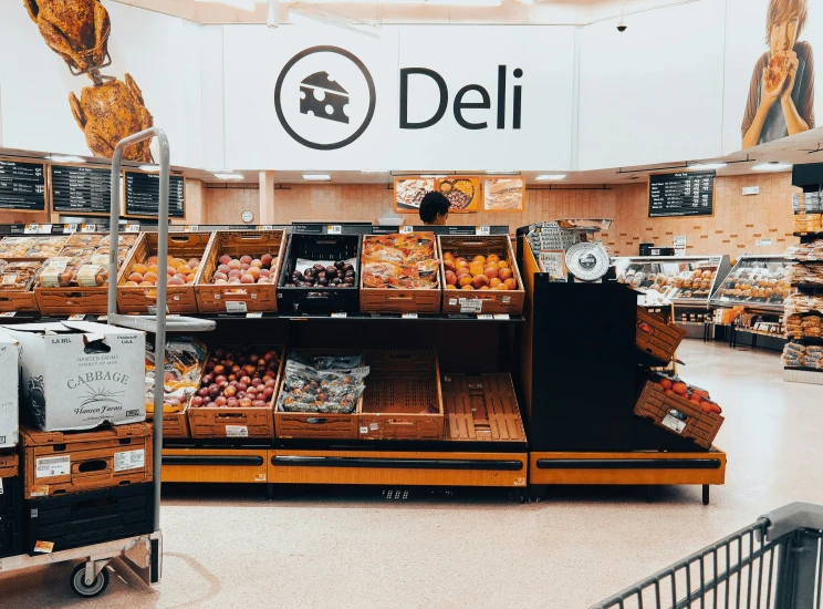 an aisle view shows the deli counters and other produce