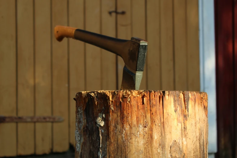 a hammer and an axe in a piece of wood