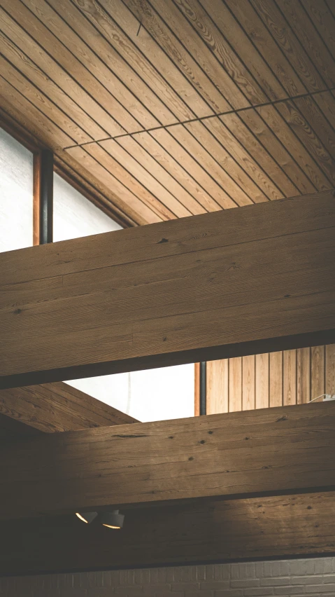 a wooden ceiling with a metal and glass window