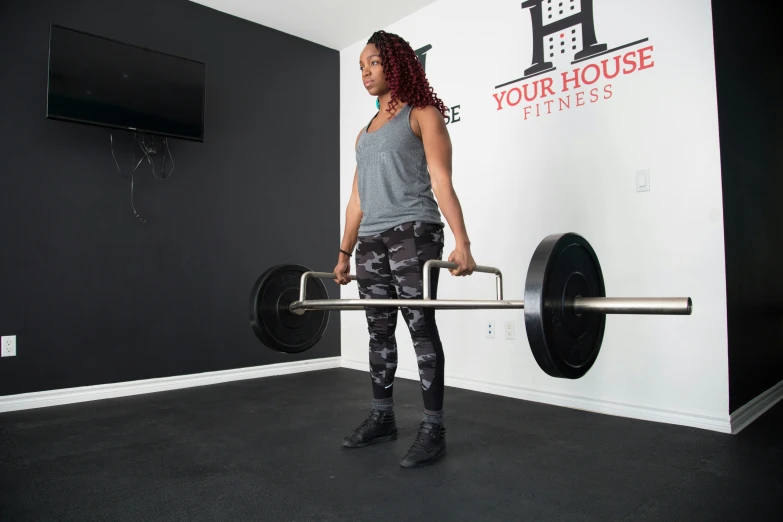 a woman doing a deadlift bar exercise in a gym