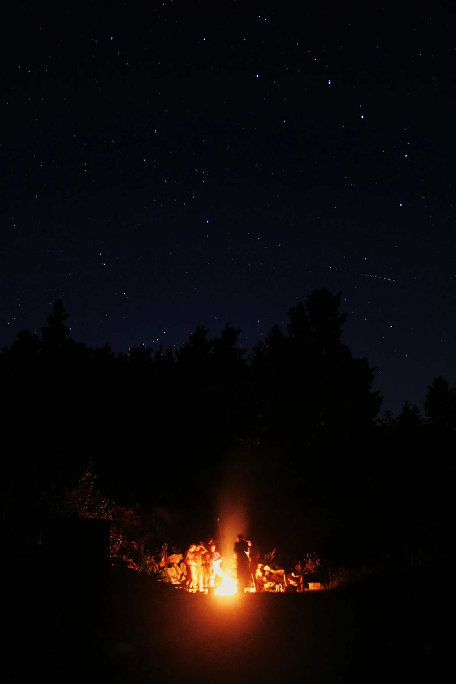 a camp site at night lit up by camp fire