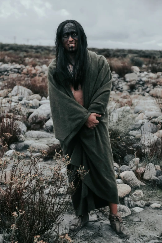 an african american man wearing clothes and a face paint in the desert