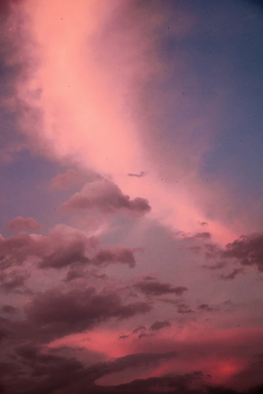 an airplane flying through the purple sky