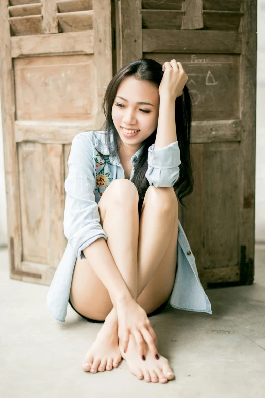 an asian woman is sitting on the ground in front of a door