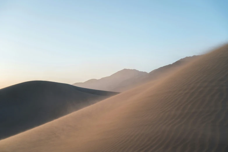 the sun is shining on some very big sand dunes