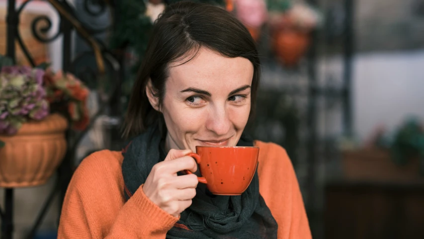 a woman eating a piece of cake and drinking coffee