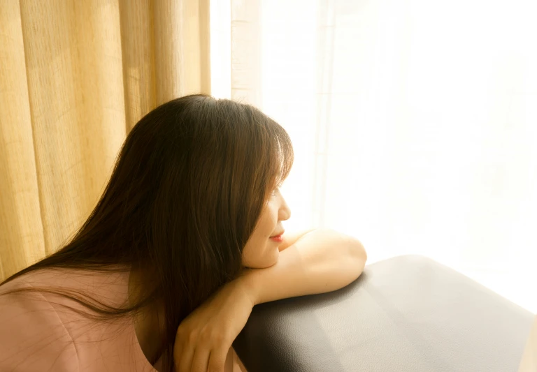 a woman with long brown hair wearing a pink shirt