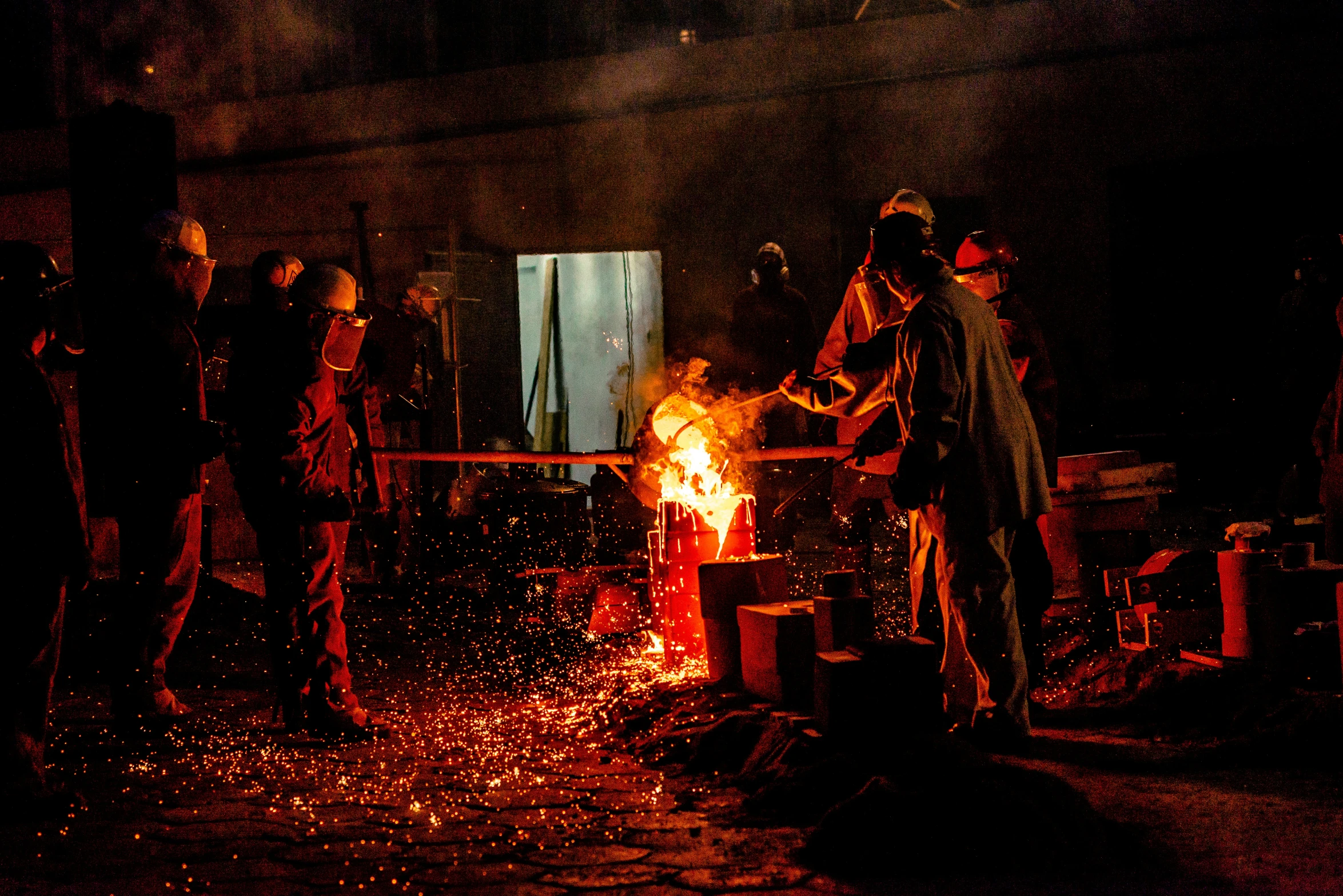 a group of people around a large fire pit at night