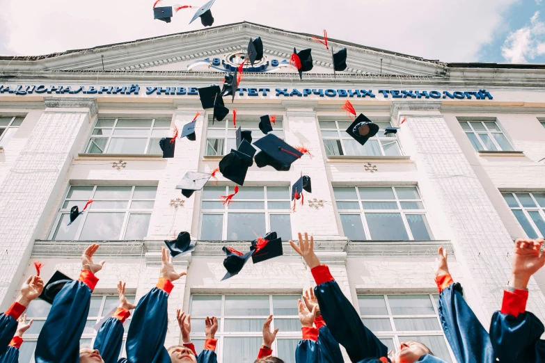 graduation caps thrown in the air and wearing graduation robes