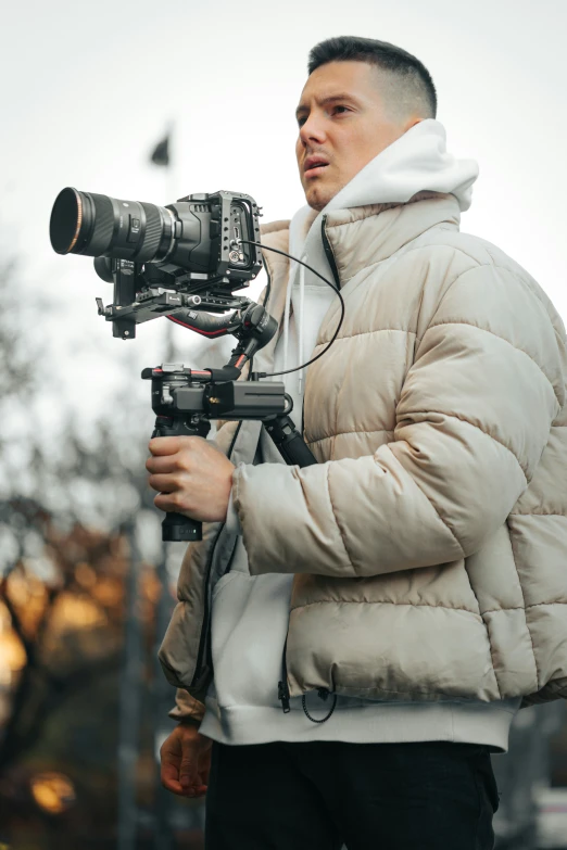 a man holding onto a camera while looking into it