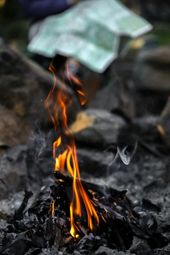 flames in a stone grill surrounded by gravel