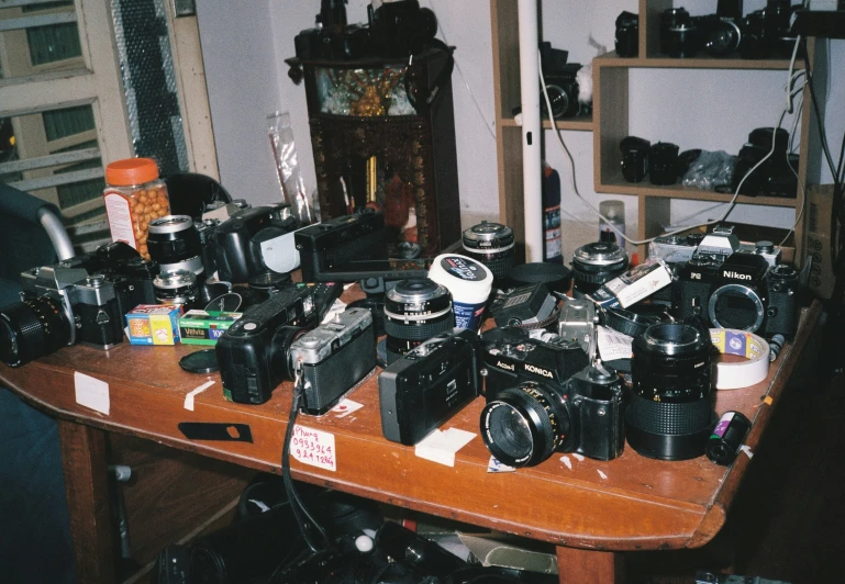 a table topped with a lot of cameras