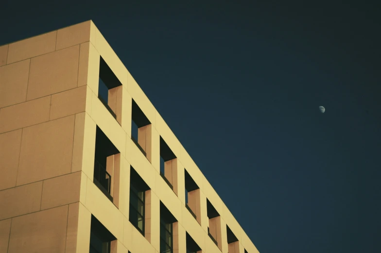 an airplane flies over the side of a building