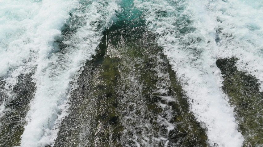 an aerial view of waves crashing on the ocean