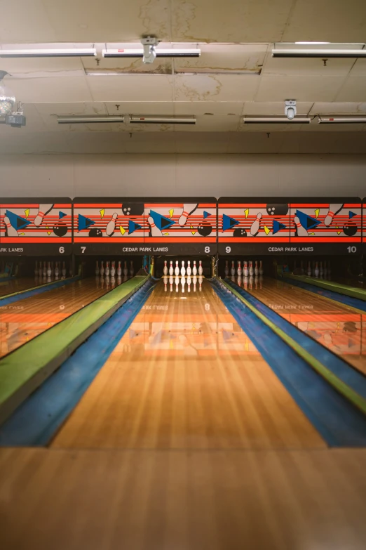 bowling pins lined up and one has a bowling pin with two lanes running through it