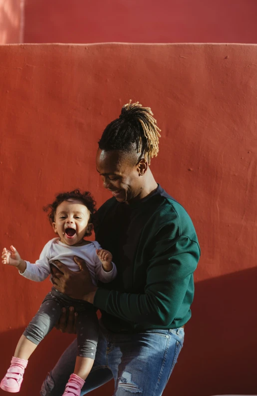 a woman holding a little girl who is screaming with her mouth wide open