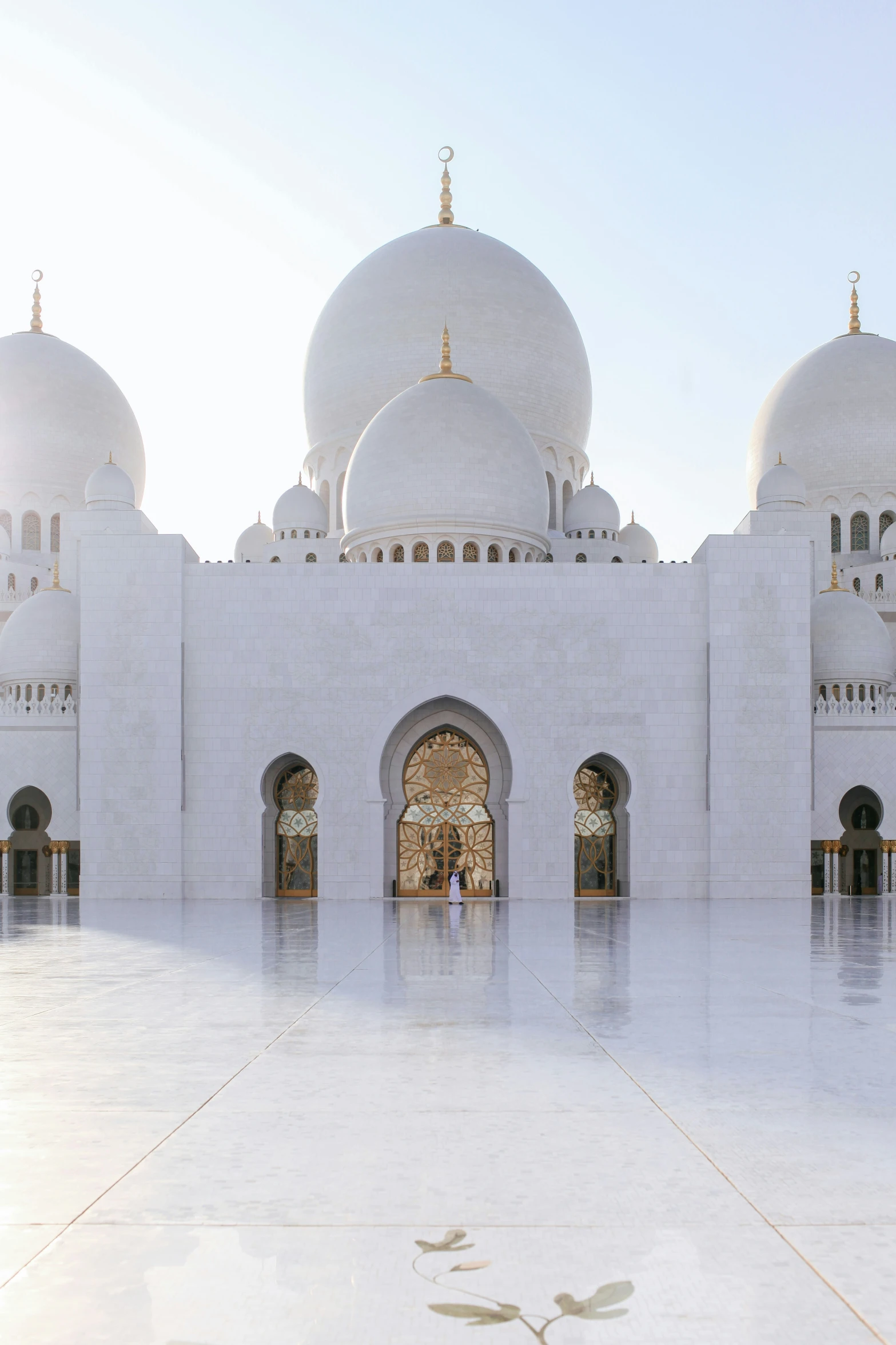 a building made out of white stone with large arches and domes