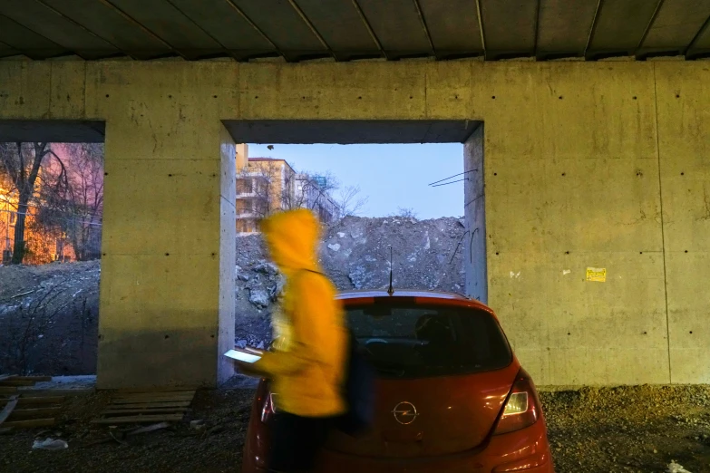 a person standing in the window in front of a red car