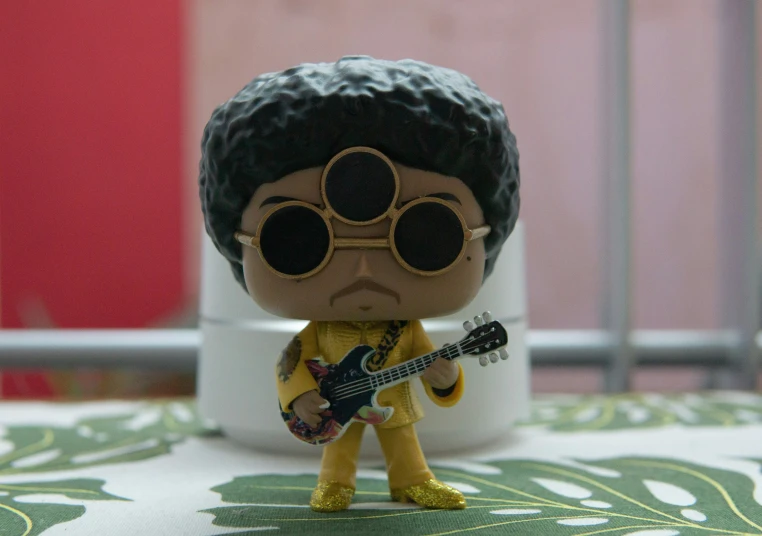 a little toy guitar player with big glasses