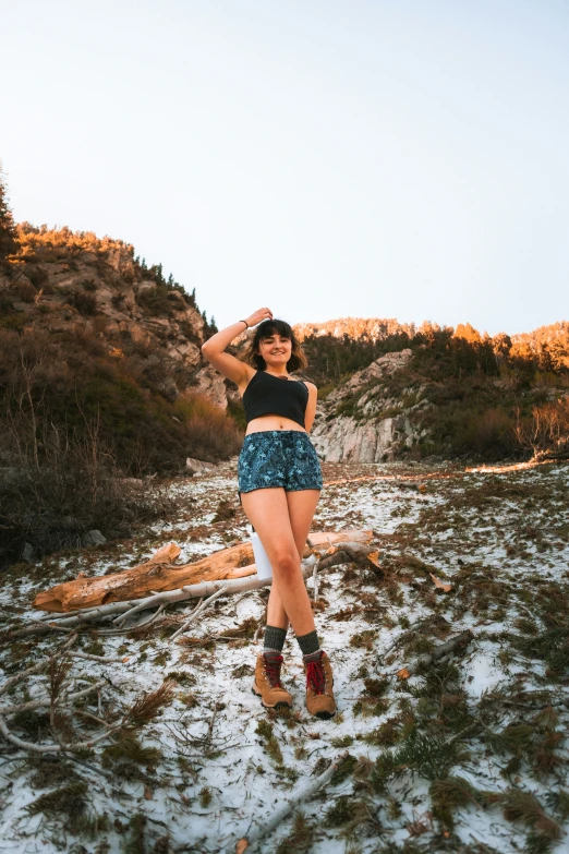 a woman in short shorts and boots posing on snow