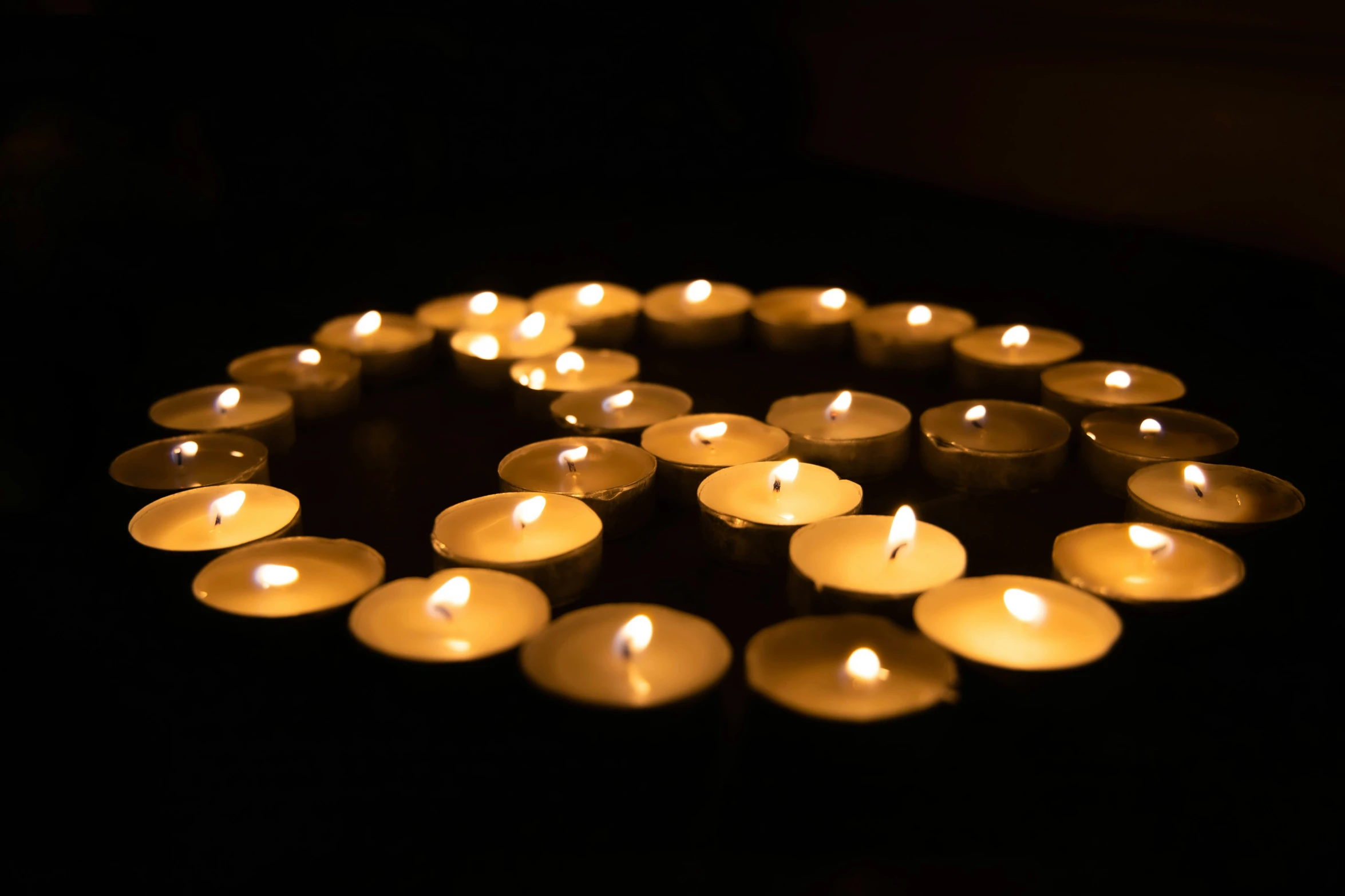 some small white candles that are glowing brightly in the dark