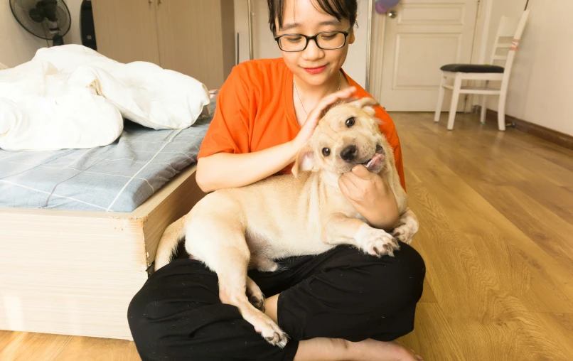 a woman sitting on the floor hugging a dog