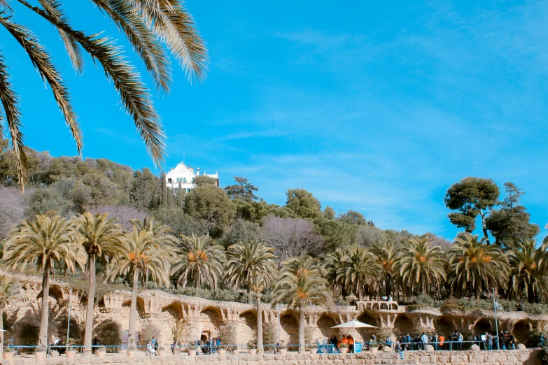 a view of a building, palm trees and some people