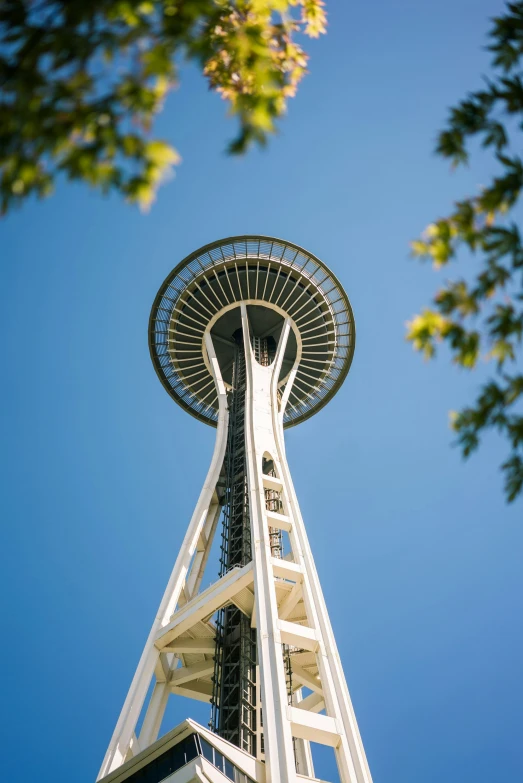 a tall structure against a blue sky with trees