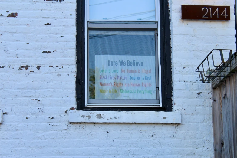 the words, written in a window of a brick building