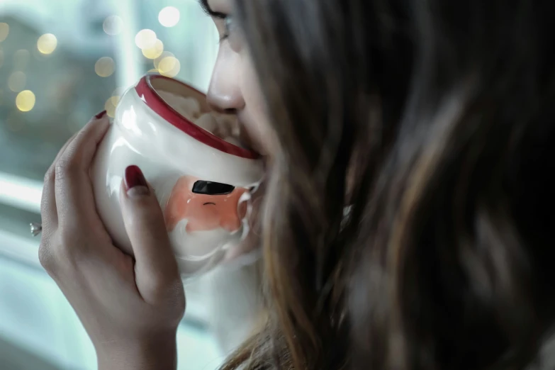 the woman is enjoying a  beverage by the window