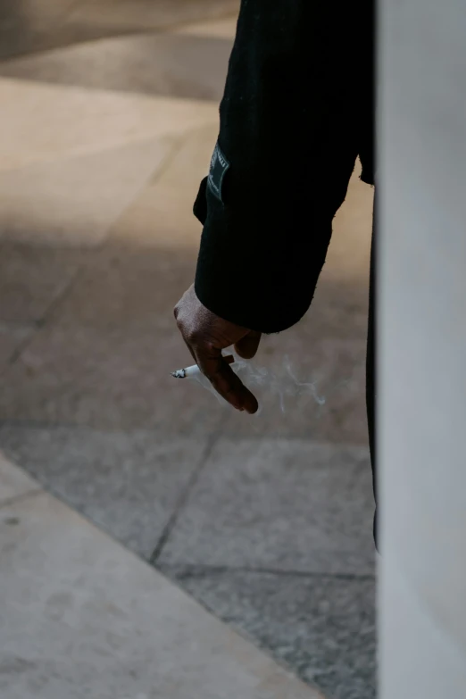 a man is holding cigarettes on the sidewalk