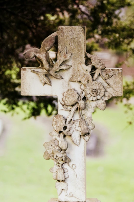 the stone cross has floral carving on it