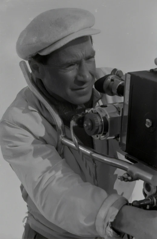 man operating video camera while standing against wall