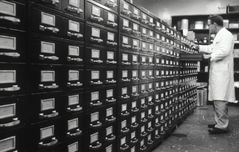 a man standing in front of an assortment of filing boxes