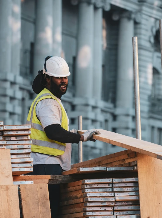 a worker at the construction site inspecting some wooden beams