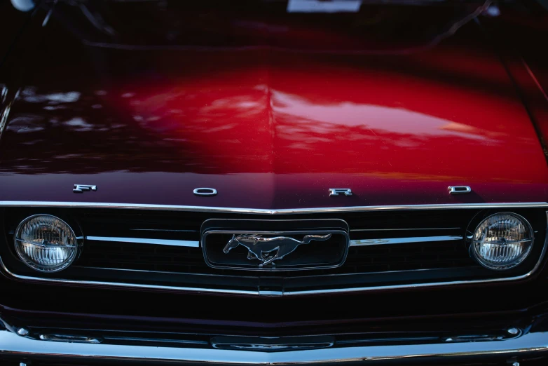 the front of an old red mustang with its hood down