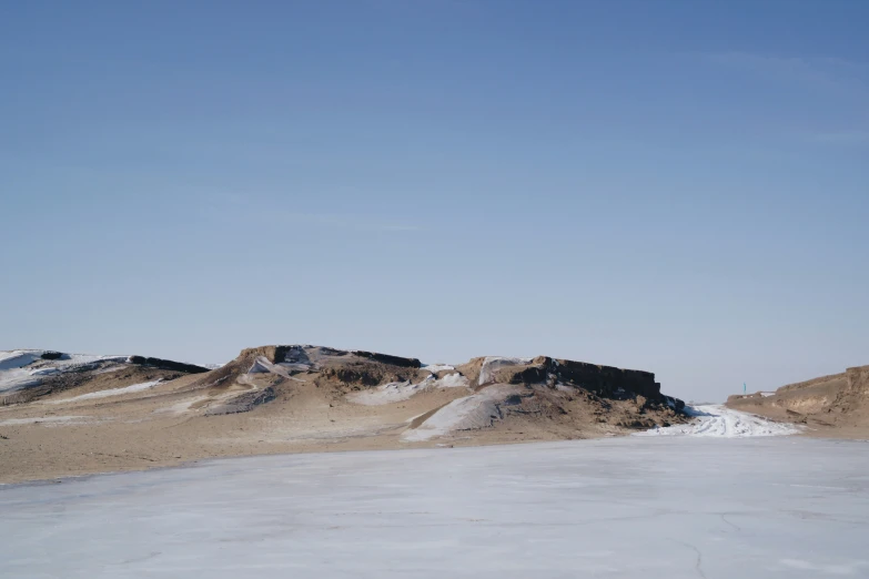 a snow covered mountain landscape with a cloudless blue sky